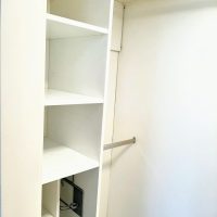 Vaatehuoneessa on pitkä vaatetanko ja hyllyjä